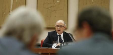 Los diputados de CiU, Josep Sánchez Llibre y Pere Macías atienden al ministro de Hacienda, Cristóbal Montoro, en el Congreso