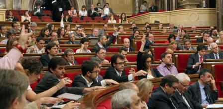 Los portavoces de las distintas formaciones marcan el sentido del voto a sus compañeros durante una votación en el pleno del Parlament.