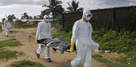 Dos sanitarios trasladan a una víctima del virus del ébola en Monrovia, Liberia