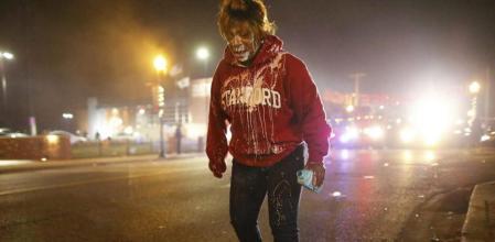 Una mujer intenta limpiarse la cara tras sufrir los efectos del gas lacrimógeno durante unas protestas en Ferguson