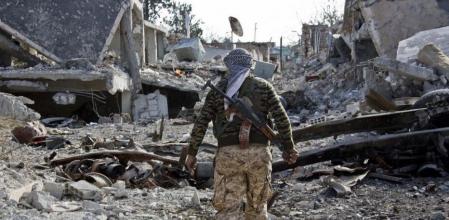 Un guerrillero kurdo contempla los destrozos causados por el atentado suicida del EI en Kobane