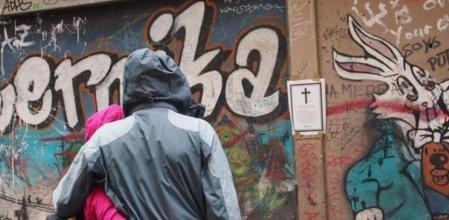 Dos viandantes mirando una de las esquelas de la acción reivindicativa 'Día de todos los Antros'