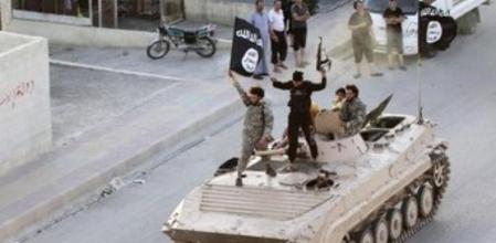 Militantes del Estado Islámico ondean la bandera de la milicia sobre un tanque por las calles de Raqqa, Siria