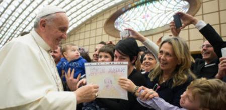 El Papa recoge el dibujo con el que le obsequia un niño en una audiencia con empleados en el Vaticano