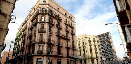 Una casa de principios del siglo XX y, al fondo, un edificio moderno, en la calle Pere IV