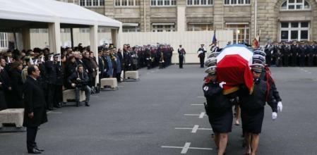 Hollande presenta sus respetos al paso de los ataúdes.