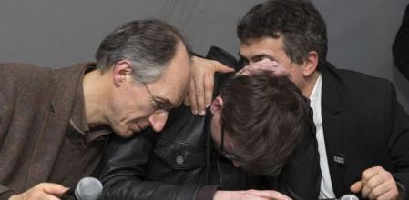 Gérard Briard y Patrick Pelloux consolando ayer al caricaturista Luz; todos son de Charlie Hebdo