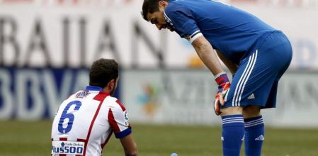 El centrocampista del Atlético de Madrid Koke Resurrección (i) conversa con el portero del Real Madrid Iker Casillas tras lesionarse en partido de la vigésima segunda jornada de liga en Primera División que se disputa esta tarde en el estadio Vicente Calderón de Madrid
