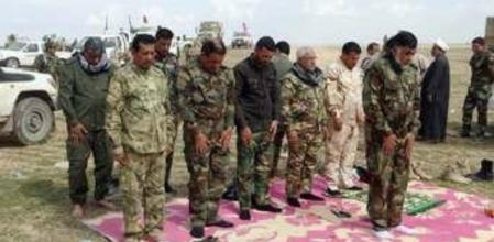 Soldados y milicianos chiíes rezan tras la toma de la localidad de Hamrin, en el curso de la ofensiva sobre Tikrit, el martes