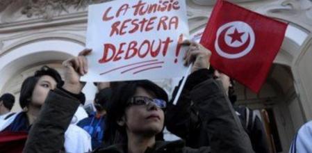 Una mujer porta un cartel en el que dice