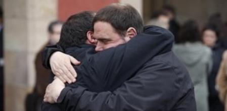 Los líderes de ERC, Oriol Junqueras y de la CUP, David Fernández, se abrazan al finalizar el minuto de silencio, realizado hoy a las puertas del Parlament de Catalunya, en señal de duelo por el siniestro del avión en el que viajaban de Barcelona a Dusseldorf 150 personas, 45 de ellos con apellido español que se estrelló en los Alpes franceses.