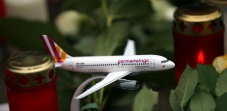 Un avión de juguete de Germanwings entre velas y flores en la sede central de la aerolínea en Colonia