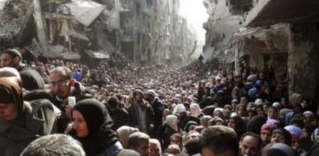 Fotografía de archivo facilitada por la Agencia de la ONU para los Refugiados Palestinos (UNRWA), fechada el 26 de febrero de 2014 que muestra a numerosos palestinos en el campo de refugiados palestinos de Al Yarmuk, en Damasco, Siria