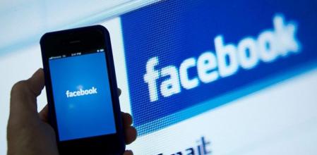 Imagen de archivo e una persona sosteniendo un móvil con el logotipo de Facebook
