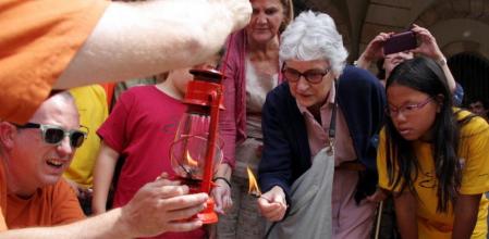 Casals, presidenta de Òmnium, enciende un quinqué con la Flama del Canigó en el Parlament junto con De Gispert
