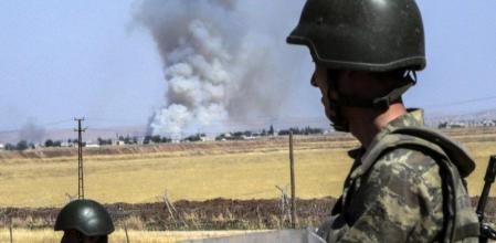 Soldados turcos patrullan la frontera siria con la ciudad de Kobane al fondo