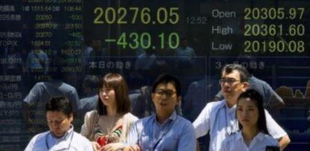 Un grupo de japoneses ante un panel informativo de la evolución de los mercados en Tokio