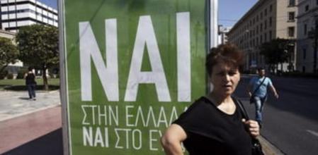 Una mujer espera el autobús junto a un cartel que pide el voto positivo en el referéndum del próximo domingo, en el que se lee: 