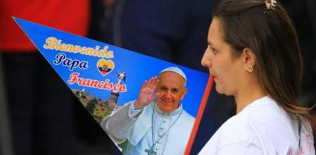 Una mujer lleva un banderín con la imagen del papa Francisco