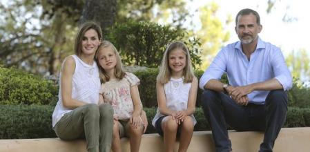 Los Reyes con sus dos hijas, sentados en uno de los pretiles de los jardines del palacio del Marivent.