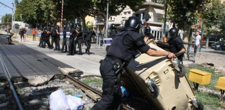 Un agente de los Mossos retira un contenedor de la vía del tren en Salou
