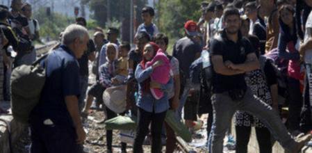 Cientos de inmigrantes esperan en una estación de tren en Macedonia un tren que les llevará a Serbia, donde caminarán hasta la frontera con Hungría