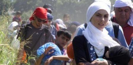 Un grupo de refugiados, en su mayoría sirios, caminan por los campos del norte de Grecia