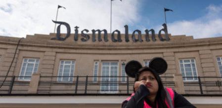 Una guardia de seguridad algo aburrida frente a las puertas del parque temático satírico creado por el grafitero Banksy