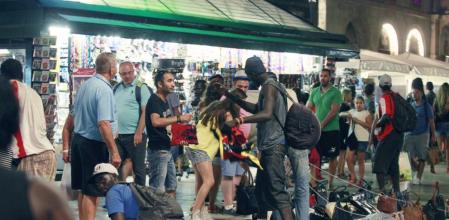 De noche. Unos manteros senegaleses vendiendo productos falsificados en la Rambla, junto al teatro Principal, el lunes.