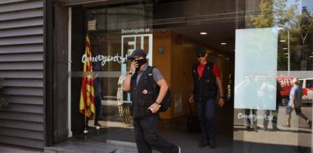 Efectivos de la Guardia Civil salen e la sede de CDC en la calle Còrsega