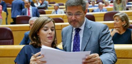 La vicepresidenta del Gobierno, Soraya Sáenz de Santamaría conversa con el ministro de Justicia, Rafael Catalá en el Senado