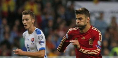 El defensa de la selección española Gerard Pique (d) escapa de Jan Gregus, de Eslovaquia, durante el partido de clasificación para la Eurocopa 2016 que se está disputando esta noche en el estadio Carlos Tartiere, en Oviedo