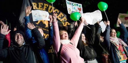 Un grupo de berlineses recibe con muestras de alegría a un grupo de refugiados