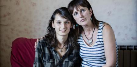 Azra y su madre, Sifa, en casa, con un reloj con el mapa de Bosnia