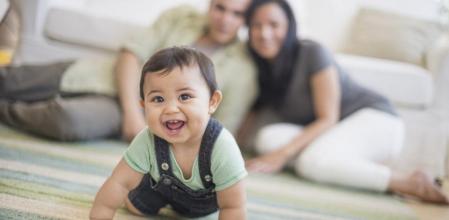 Un bebé gatea ante la mirada de sus padres