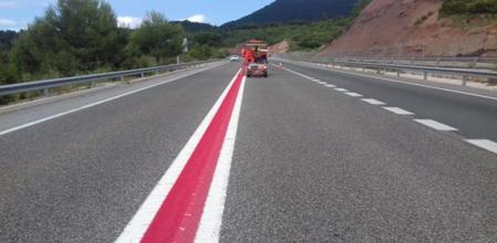 Unos operarios pintan una línea roja en una carretera del Eix Diagonal, en Catalunya&nbsp;