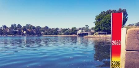 Indicador de la subida del nivel del mar en el puerto de Sídney, en el que se muestran los registros en las mareas altas en&nbsp; los años 1920 y 2006, así como la proyección para 2050