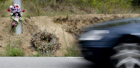 Un ramo de flores y una corona recuerdan un accidente mortal en una carretera convencional