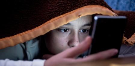 Una adolescente consulta su teléfono móvil