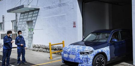 Una unidad de preserie camuflada del nuevo iX3 sale de la planta de producción en China (BMW)