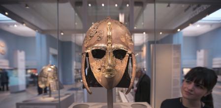 Una mujer observa una de las piezas halladas en el 'Sutton Hoo'.