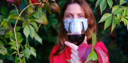Mujer con mascarilla y copa de vino