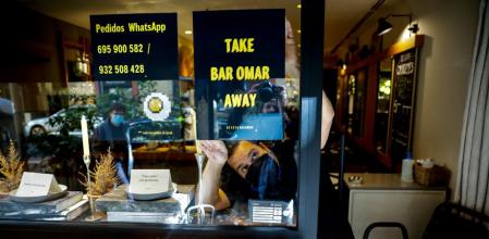 Omar Díaz cuelga el cartel con la oferta de comida para llevar en su  Bar Omar (Amigó, 34)