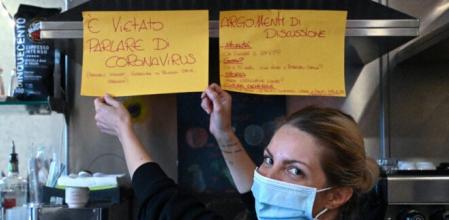 Cristina Mattioli, copropietaria de Feeling Bar, muestra los dos carteles que ha colocado en su establecimiento