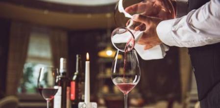 Un sumiller sirviendo vino en la sala de un restaurante