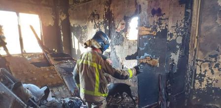 Un bombero inspecciona el interior calcinado de la nave de Badalona