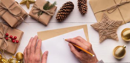 Christmas greeting card. Man writing letter to Santa Claus, white wooden table with xmas presents and ornaments, copy space (Christmas greeting card. Man writing letter to Santa Claus, white wooden table with xmas presents and ornaments, copy space, A