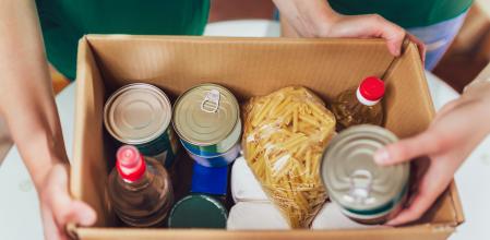 Volunteer with box of food for poor. Donation concept.