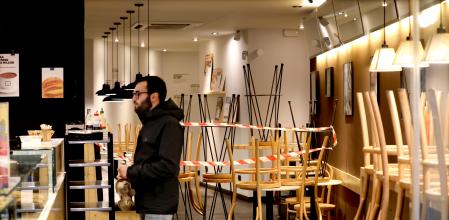 foto XAVIER CERVERA 21/03/2020 en el octavo dia de confinamiento decretado por el gobierno 'estado de alarma' (coronavirus) ,solo salir para ir a necesidades basicas, comida ,farmacia, o pasear perro... en una tienda cafeteria del carrer carme se ve claramente como han prohibido (por riesgo a multa) sentarse a tomar cafe u otros, y solo se puede comprar comidas bebidas ,de pie, e irse; un cliente espera su pedido de take away
