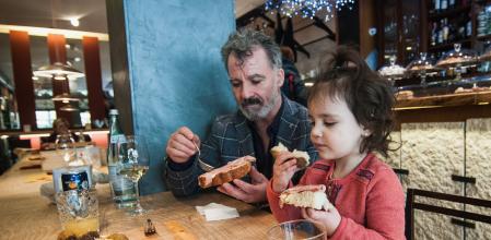 PADOVA, ITALY - FEBRUARY 15:  A child eats with her parents for lunch at a table in the Antonio Ferrari restaurant on February 15, 2017 in Padova, Italy. The restaurant offers a 5% discount off the total food bill if children are well behaved throughout their lunch or dinner.  (Photo by Awakening/Getty Images)